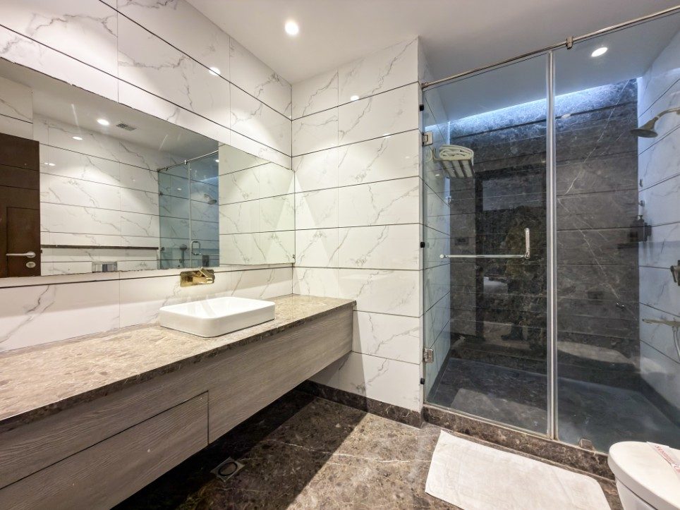 Marble bathroom with glass walk-in shower in a Business Room, Hotel Sawera Grand
