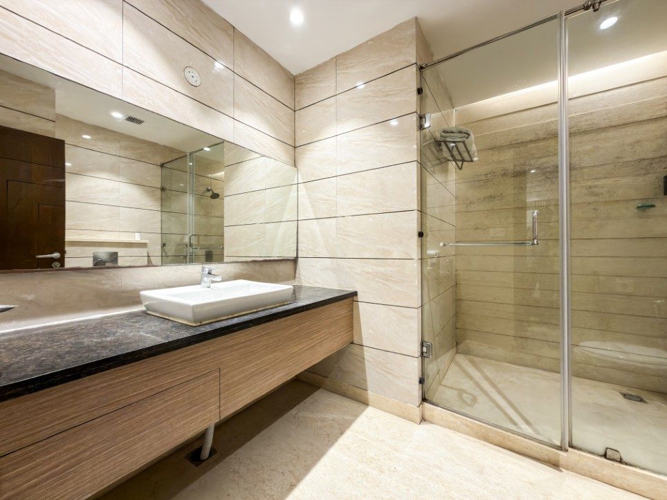 Marble bathroom with glass walk-in shower in a Business Room, Hotel Sawera Grand