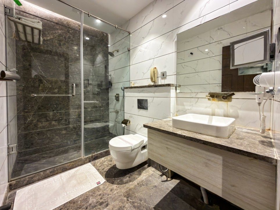 Marble bathroom with glass walk-in shower in the Executive Room, Hotel Sawera Grand